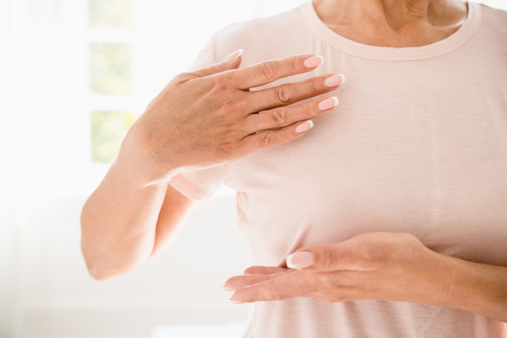 Woman doing palpation of breast for prevention cancer. Self-checking medicine. World cancer day